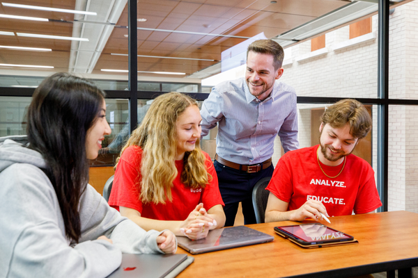 Professor Taylor Odle smiling while working with EPS undergraduate students.