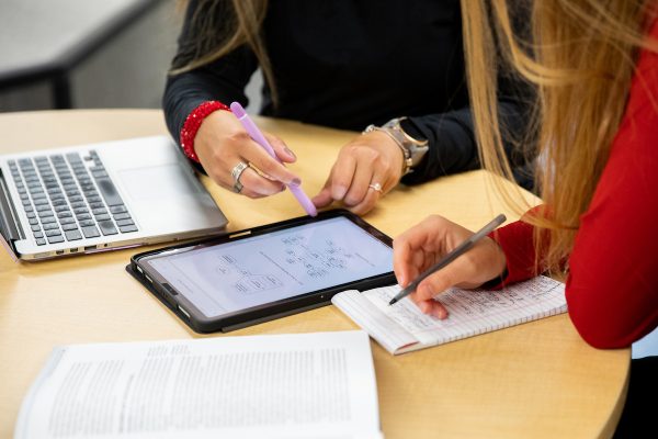 two students working on a laptop